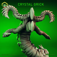 Digital render of the Crystal Grick miniature by The Toadstool Weaver — an unpainted grey resin sculpt of a worm-bodied aberration with four grasping tentacle-arms tipped with hooked claws, a wide maw ringed with smooth crystal facets, and large gemstone shards erupting from its segmented body, shown rearing upright against a vivid green background at 32mm scale