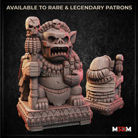 Digital render of the Cursed Fertility Idol miniature showing front and rear views — a squat demonic figure with a wide snarling mouth, pointed ears, and a necklace of tiny soul-faces, clutching a skull-topped staff, seated on an ornately carved plinth covered in miniature anguished faces