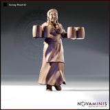 32mm unpainted resin miniature of a broad, cheerful tavern serving woman with braided hair, arms outstretched holding two large tankards in each hand, wearing a laced bodice and layered skirt — Serving Wench 02 by Novaminis