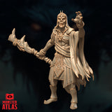 Full-body render of the Deathlock Mastermind miniature in a commanding pose, holding a gnarled bone staff in one hand and raising a splayed claw with the other, wearing a flowing tattered robe — unpainted gold-toned render by Monster Atlas