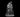 Grey resin digital render of a Dragonborn Druid miniature at 32mm scale — an upright figure in a fur-trimmed cloak gripping a tall gnarled staff with both clawed hands, wearing a horned dragon skull mask and scaled leg armour, mounted on a round base