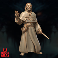 Robed male spellcaster standing upright, right hand raised palm-out at chest height, left hand holding a slender wand. Wide embossed runic cape over long flowing robes with belted pouch. Sculpt by Monster Atlas.