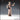 32mm scale unpainted resin miniature of Maid 01 by Novaminis — a medieval woman in a laced bodice and long skirt, one hand raised in a warning gesture, braided hair held by a headband, wide-eyed expression of alarm