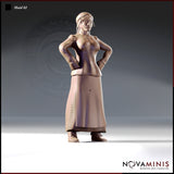32mm scale unpainted resin miniature of Maid 02 by Novaminis — a medieval woman in a fitted bodice and long laced skirt, standing with both hands planted firmly on her hips in a confident, authoritative pose