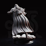 Hooded crossbow knight crouching forward with a heavy crossbow raised to aim, wearing layered plate armour, chainmail hood, and a flowing cloak. Sculpted base of cracked stone. Sculpt by DM Stash.