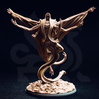 Unpainted resin miniature of Exelian the Forbidden viewed from the front — multi-armed undead horror with spread wings formed from membrane and sinew, coiled serpentine tail base, clawed hands raised, and a hooded skull-faced head, mounted on a rubble and skull-strewn scenic base