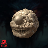 Front-facing digital render of the Eye Monger miniature — a rough-textured spherical aberration with a single large bulging eye and a wide row of jagged teeth along its lower face, shown in unpainted sandy resin tone against a dark background