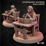 Digital render of an unpainted resin miniature showing a female Dungeon Master seated at a rustic wooden table, holding a polyhedral die in one raised hand, with an open GM screen and wooden tankard on the table. Shown from front and rear angles on an oval scenic base. Labelled as a Legendary Patron Exclusive by M3DM.