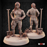 Digital render of the Female Farmer Fighter miniature by Mia Kay M3DM, shown from front and back. She is an unpainted grey resin figure with braided hair, stitched working clothes, and a smirk. She stands with one hand on her hip and leans on a long-handled rake, with wild grasses on her detailed earth base.