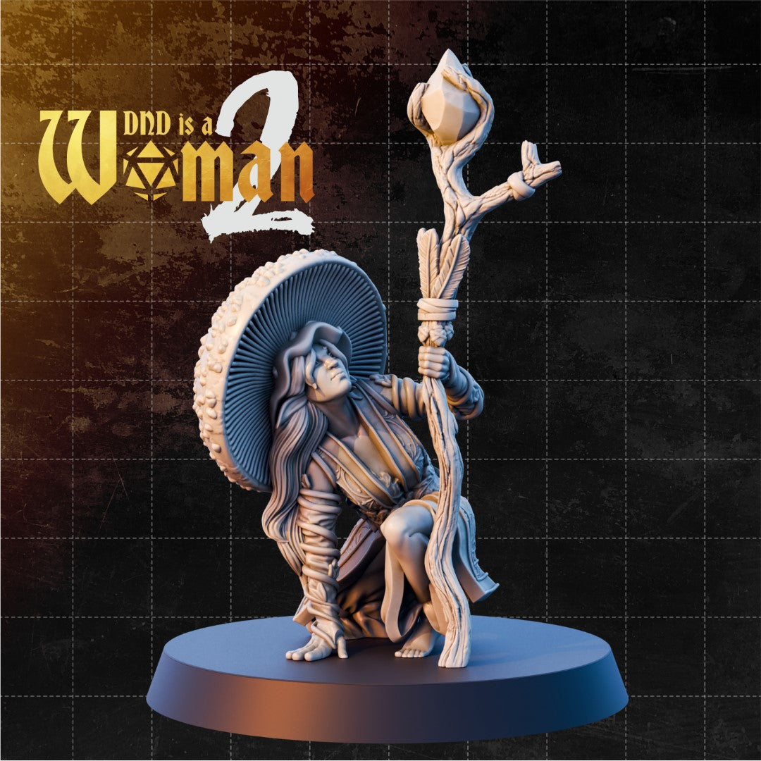 Firbolg druid kneeling with a large mushroom cap fanning behind her, gripping a rope-and-feather-bound nature staff topped with a closed bud. Sculpt by DnD is a Woman.