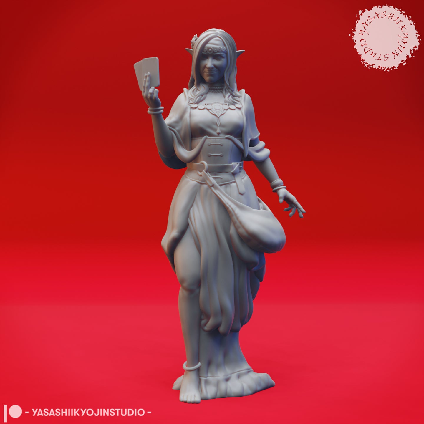 Front view of an unpainted grey resin miniature of a female elf fortune teller, holding a tarot card aloft in one raised hand with fingers splayed on the other, wearing layered flowing robes, a jewelled headband, and bangles, sculpted by Yasashii Kyojin Studio