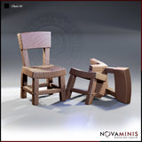 Two resin scatter terrain chair sculpts side by side — one intact with a straight back and plank seat, one shattered with legs splayed and back collapsed. Deep wood grain and bolt detail throughout. By Novaminis.