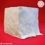 Digital render of a Gelatinous Cube miniature by Yasashii Kyojin Studios, showing a looser fabric-like drape with material pooling at the base, in cream and pale blue tones, viewed from a front-corner angle against a red background