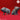 Two unpainted grey resin pig miniatures from Yasashii Kyojin Studio — one standing with a low belly and sideways glance, one seated with snout raised, both on a red background