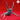 Grey unpainted resin giant spider miniature in a rearing threat pose — forelegs raised high, curved fangs spread wide, viewed from the front at low angle against a red background. Sculpted by Yasashii Kyojin Studio.