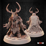 Goblin Shaman miniature by Mia Kay M3DM: hunched figure with both clawed hands raised, wearing antlered headdress, sinew face wrappings, layered fur and cloth robes bound with rope, on a cobblestone base. Front and rear views shown.