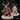 Goblin Shaman miniature by Mia Kay M3DM: hunched figure with both clawed hands raised, wearing antlered headdress, sinew face wrappings, layered fur and cloth robes bound with rope, on a cobblestone base. Front and rear views shown.