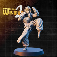 Goliath Monk Axya sculpt by DnD Is A Woman — female figure mid-high kick, knee raised, both arms coiled with cloth wrappings, loose flowing hair, prayer-bead belt, bare feet.