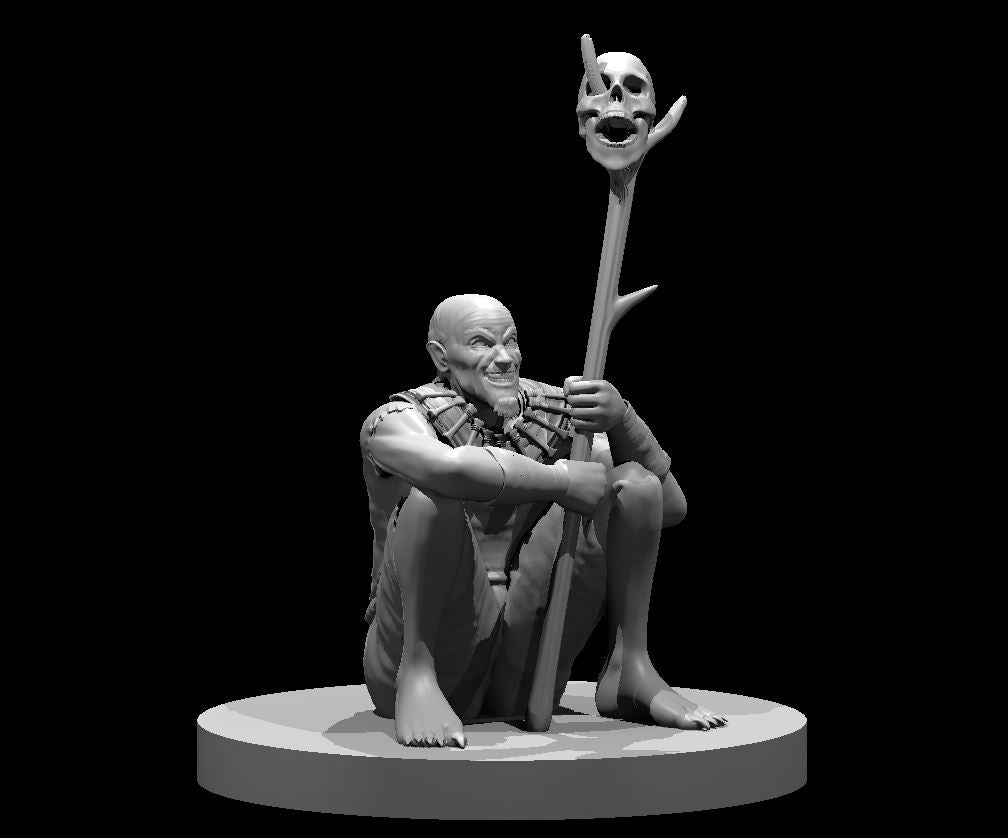 Grey resin digital render of a seated male green hag miniature at 32mm scale, gripping a gnarled staff topped with a horned skull, wearing bone fetishes at his chest, with clawed feet and a wide sinister grin, mounted on a round base