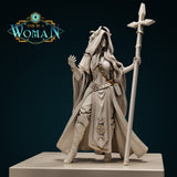 Hooded hexblood cleric holding a tall cross-tipped staff in one hand, fingers of the other hand raised mid-cast, wearing pentagram-buckled belt and moon-symbol tabard over a laced corset bodice. Sculpt by DnD Is A Woman.
