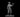 Grey resin digital render of a 32mm human male artificer miniature — masked face, tricorn hat, long coat, holding a potion vial aloft in one hand and a tome under the other arm, mounted on a round base