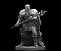 Unpainted grey resin digital render of a human male druid miniature at 32mm scale, gripping a long serpent-topped staff across his body in a guarded stance, wearing a heavy fur mantle over layered travelling clothes with wrapped legs and worn boots, fierce expression, on a round base