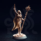 Unpainted resin miniature of Ilisyia the desert elf priestess, photographed against a dark background. Front view showing the intricate detail of her eight-pointed star mace head, knotted sash, patterned skirt fabric, and armour bracers, with her ritual blade raised skyward. 32mm scale tabletop miniature on a desert rubble base.