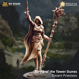 Digital render of Ilisyia of the Tower Dunes desert elf priestess miniature, showing her in a dynamic pose with a star-headed solar mace in her left hand and a ritual blade raised aloft in her right, wearing layered desert robes, a hooded cowl with pointed ear guards, engraved bracers, and a billowing cape — standing on a sandy rubble base. DM Stash Elves of the Golden Sun range.