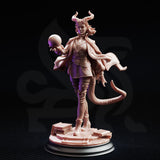 Three-quarter front view of Ivy Dupré miniature against a dark background — unpainted resin, showing her quilted tunic, wide leather belt, knee-high boots, billowing open cape, tiefling horns and tail, and arcane orb raised in her outstretched hand