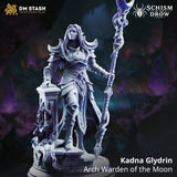 Rear view of Kadna Glydrin by DM Stash — flowing hair and cloak visible, crescent-moon staff raised high, back detailing on layered armour and skirt panels, ruined pillar base with organic vine growth.