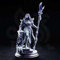 Kadna Glydrin Arch Warden of the Moon — armoured female elf raising a crescent-moon staff, resting one hand on a ruined stone pillar, long hair loose, detailed plate and fabric armour. DM Stash sculpt.