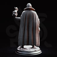 Bare-chested male warlock standing upright, raising a twisting warlock flame in his right hand and gripping a bound effigy head in his left, wearing a heavy linen cloak and runic arm wraps. Sculpt by DM Stash.
