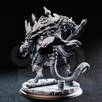 Rear three-quarter view of the DM Stash Rat King resin miniature — showing spiked back with protruding blades, a long rat tail, heavy armoured torso, and broken stone base with scattered cannon debris