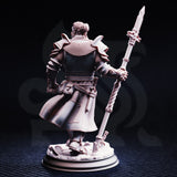 Rear view of the Krunthar half-orc knight resin miniature, showing chainmail cape draped from broad pauldrons, detailed back plate armour, a utility belt with pouches, and the twisted shaft and ornate tip of his warspear raised to the right.