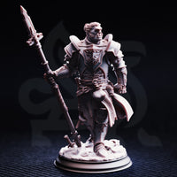 Front view of an unpainted grey resin 32mm miniature of Krunthar — a half-orc knight in layered plate armour with a heraldic breastplate sigil and cross-belt detailing, wielding an ornate warspear, standing on a sculpted rubble base with a broken sword beneath his feet.