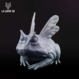 Cornuta Toad by La Louve 3D — warty toad in a low seated pose, insect wings folded across its back, hooded eyes and splayed webbed toes visible, textured nodular skin throughout.
