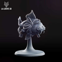 Rotund fish miniature viewed from behind, showing twisted rope bindings looped around its body with bells attached, broad swept fins and a split fantail with fine vein detail. Sculpt by La Louve 3D.