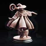 Rear view digital render of Lady Elara miniature showing the dramatic swept volume of her layered robes in motion, the spiral horn ornament on her hat, and her cat familiar's detailed fur texture on the engraved circular base