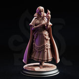 Lune de la Rue 32mm resin miniature by DM Stash — front three-quarter view of unpainted grey resin sculpt showing detailed lace hem, embossed bodice, wide capelet cloak, and arcane flame above the raised hand, mounted on an open-book flagstone base