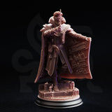 Side-angle render of Luther Fleck miniature — unpainted grey resin showing the full figure with monocle, knotted rope chest fastenings, wide dramatic cloak with book-lined interior relief, and a detailed stone base scattered with candles and small vessels