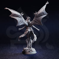 Unpainted grey resin miniature of Luxuria of the Second photographed from the rear, showing the full spread of her veined bat wings, flowing cloth garments, and detailed textured base — highlights the quality of the back-of-sculpt detail