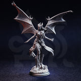 Unpainted grey resin miniature of Luxuria of the Second photographed front-on, showing her outstretched arms, sweeping bat wings with clawed tips, horned head with flowing hair, and detailed rocky base on a circular plinth