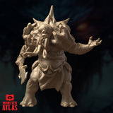 Three-quarter front render of the Maelephant miniature without its polearm, showing the full torso detail including layered bony chest plates, multiple appendages framing the head, the elephantine tusk maw, and one splayed clawed hand raised outward. The spiked crown and overall bulk of the creature are prominently displayed. Monster Atlas, 32mm scale.