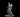 Grey resin digital render of a female elven mage apprentice miniature at 32mm scale — bald head, long flowing robes, a ball of flame conjured in her raised right hand, mid-stride pose on a round integrated base
