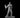 Grey resin digital render of a bald male mage apprentice miniature, standing mid-cast with an open spellbook in his left hand and conjured flames rising from his right palm, wearing long flowing robes with a high collar, on a plain round base — 32mm scale D&D miniature by MZ4250