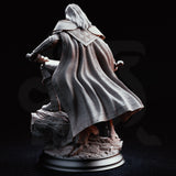 Masked dual-wielding fighter crouched on a rocky base, falchion sweeping low and curved blade thrust forward, wearing a quilted hood, scaled pauldrons, and layered coat. Sculpt by DM Stash.
