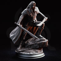 Masked dual-wielding fighter in a deep crouch, falchion angled downward and short blade extended, coat falling open to reveal belted leather armour beneath. Scenic rubble base. Sculpt by DM Stash.