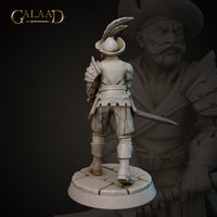 Rear view of the same unpainted grey resin mercenary miniature by Galaad Miniatures, showing the feathered tricorne hat from behind, riveted pauldron on the right shoulder, layered fabric tassets at the waist, and the long sword visible at his side. Cobblestone round base. 32mm scale.