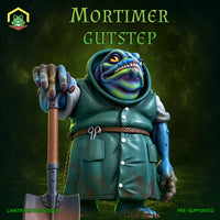 Stocky frogfolk figure in a buttoned teal coat, leaning on a shovel, wide grinning mouth, golden eye, scissors in pocket, dark clawed nails. Sculpt by The Toadstool Weaver.