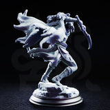 Drow female rogue lunging forward with twin curved blades, wearing skull-trimmed pauldrons and a scaled cloak swept back. Fine hair detail and skull bracers visible. Rocky base. Sculpt by DM Stash.